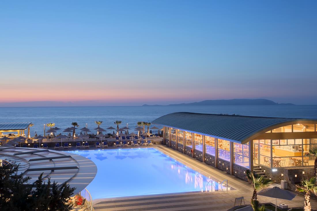 Poolbereich und Liegen im Garten/Aussenbereich mit Poolrestaurant und Poolbar am Strand im Arina Beach Kreta - Copyright © Arina Beach
