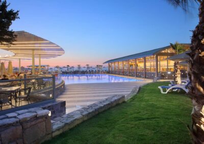 Hauptpool und Liegen im Garten/Aussenbereich und Strandbar / Poolbar bzw. Strandcafe am Strand im Arina Beach Kreta am Abend - Copyright © Arina Beach